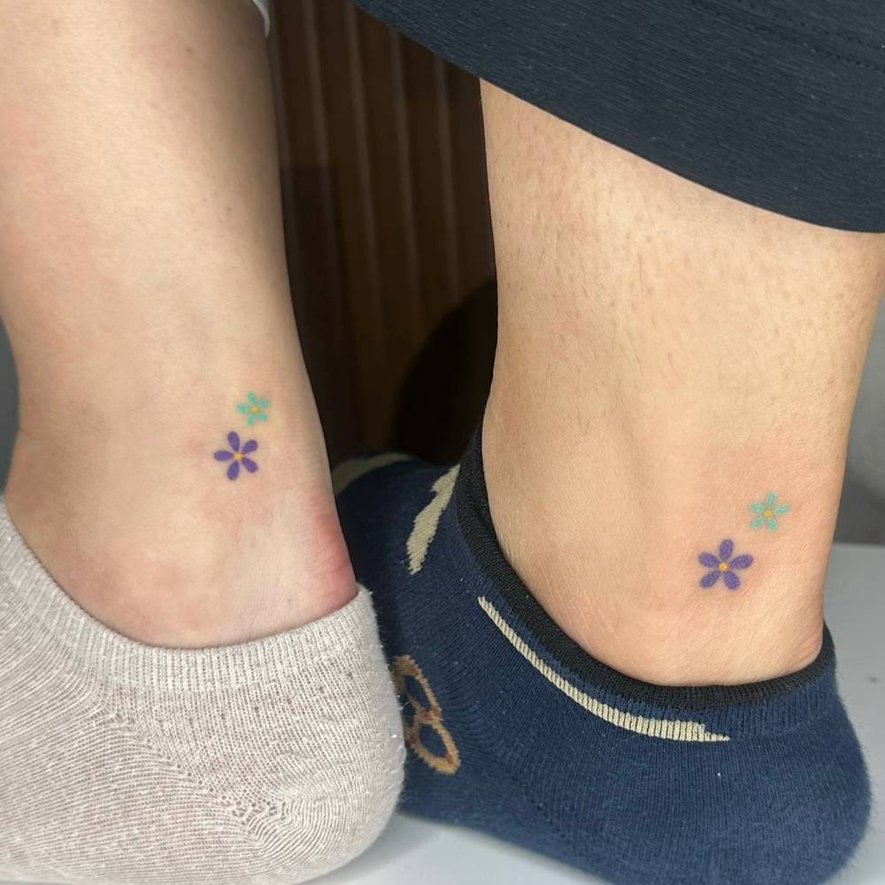 Matching minimalistic hand poked flower tattoo for best friends.