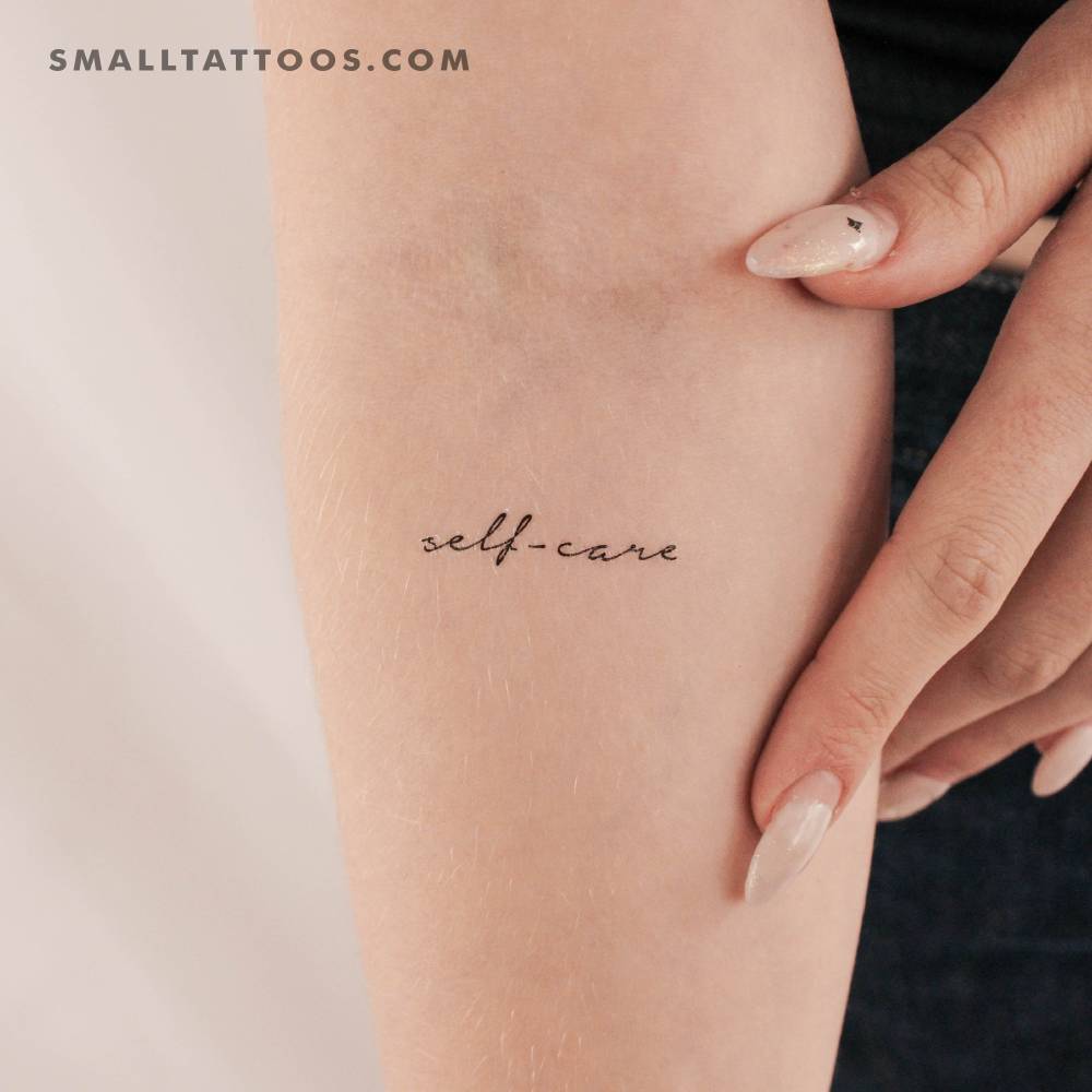 Handwritten font "self-care" temporary tattoo located on the inner forearm.