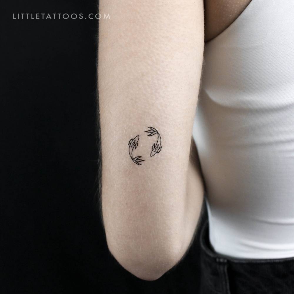 Two opposite fish temporary tattoo located on the tricep.