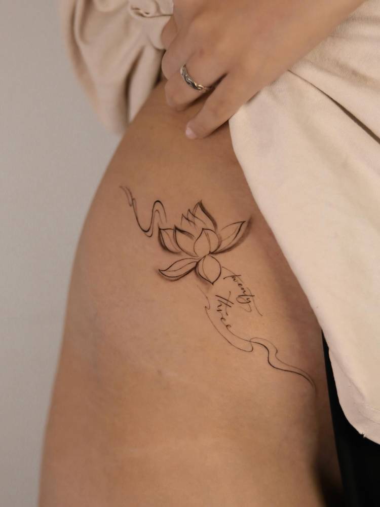 Lotus flower tattoo in illustrative style located on the pelvis.