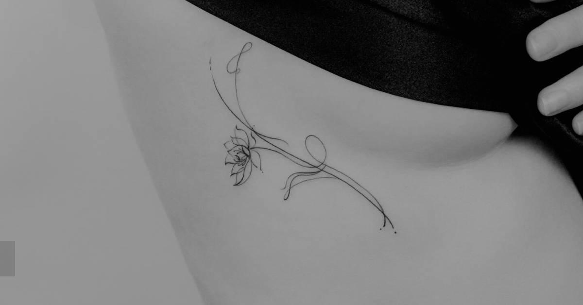 Lotus flower tattoo in fine line style located on the