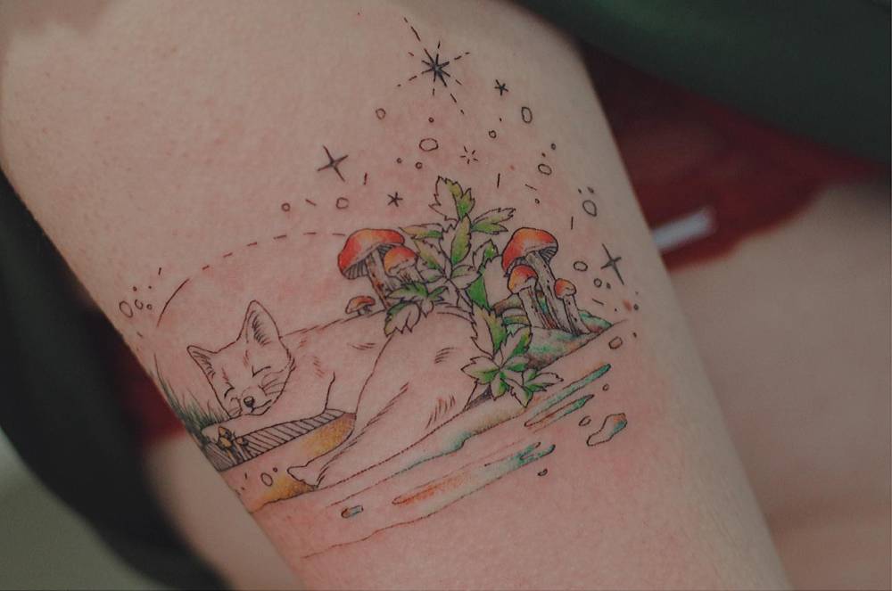 Sleeping fox tattoo in cartoon style located on the inner forearm.