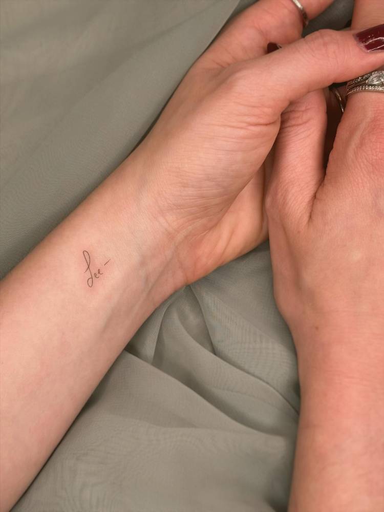Handwritten font name "Lee" tattooed on the wrist.