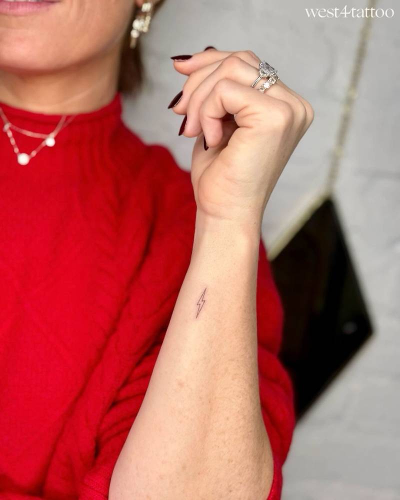 Tiny minimalistic lightning bolt tattoo placed on the wrist.