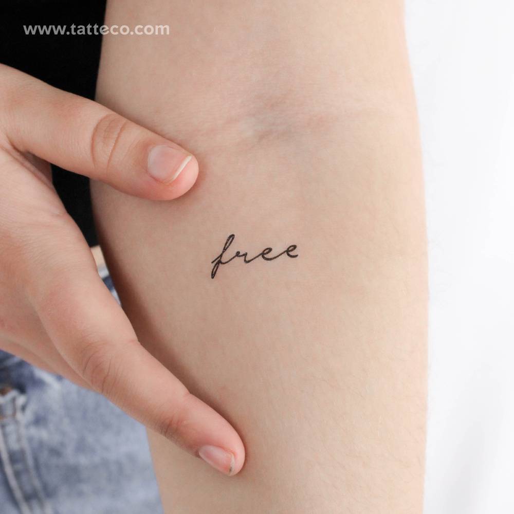 Handwritten font word "free" temporary tattoo located on the inner forearm.