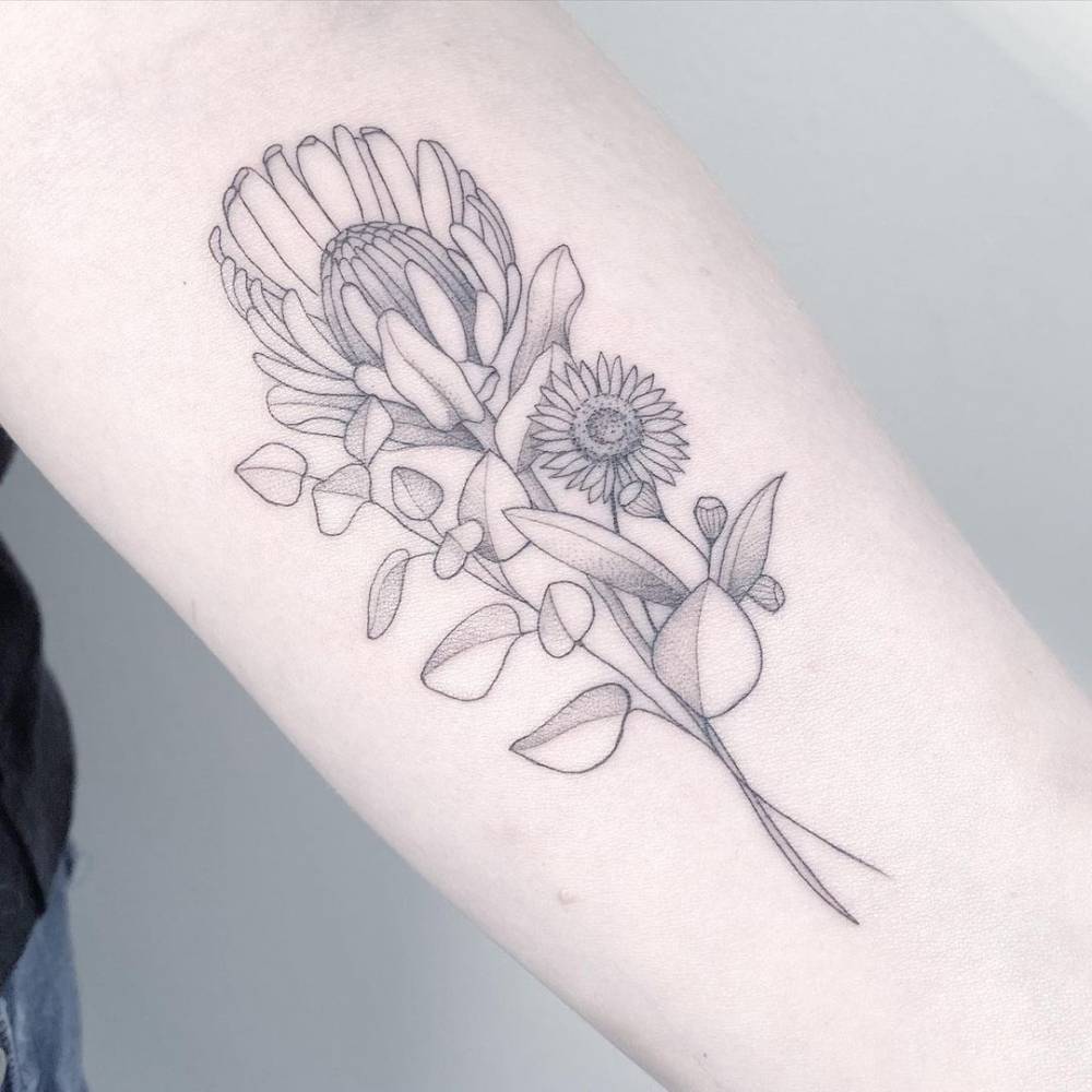 Fine line flower bouquet tattoo on the inner forearm.