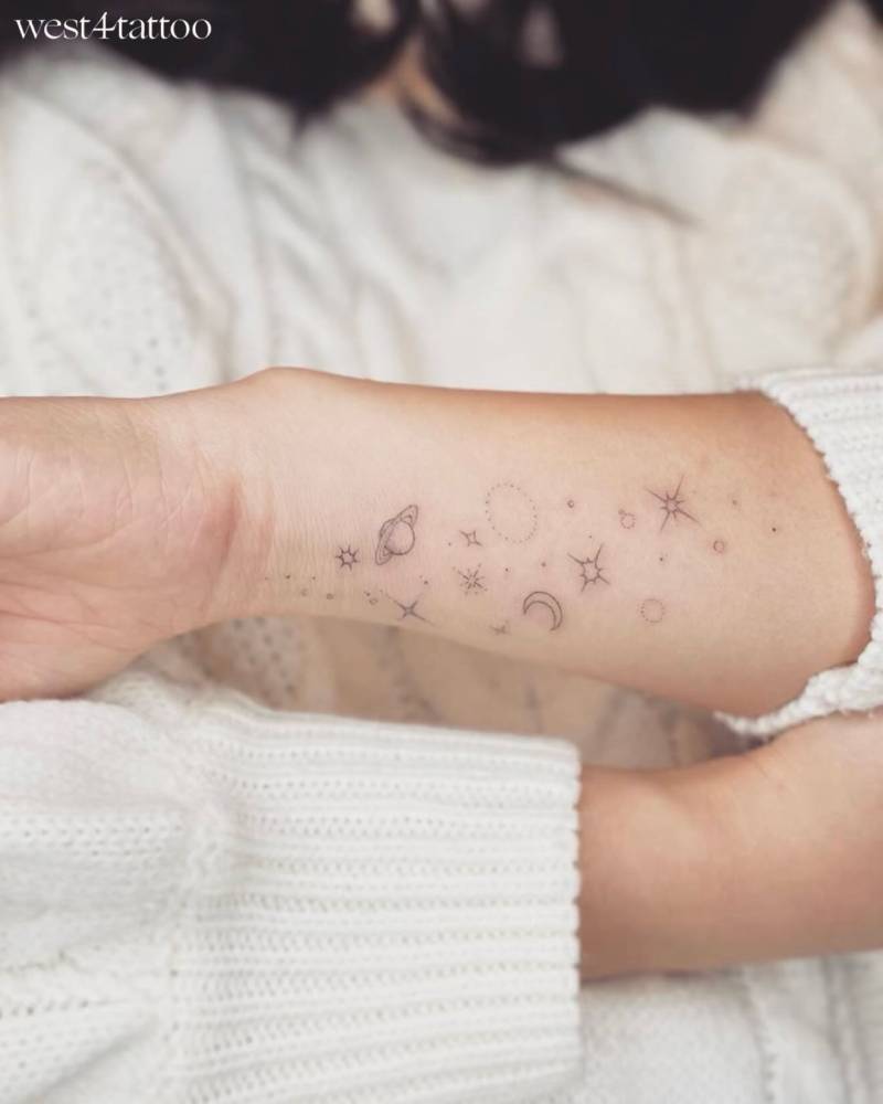 Universe tattoo in fine line style located on the wrist.