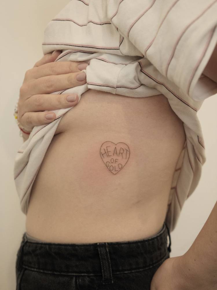 "Heart of gold" inside a heart tattooed on the rib.