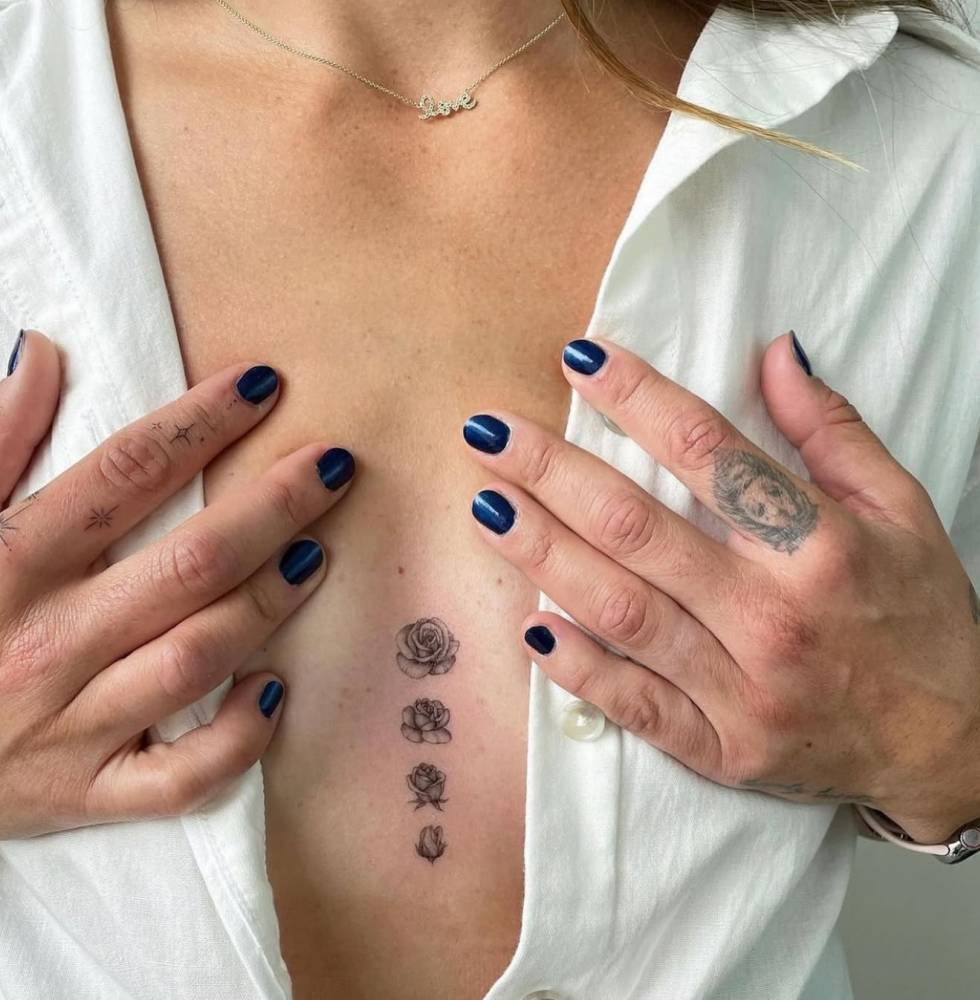 Blooming rose tattoo located on the sternum.