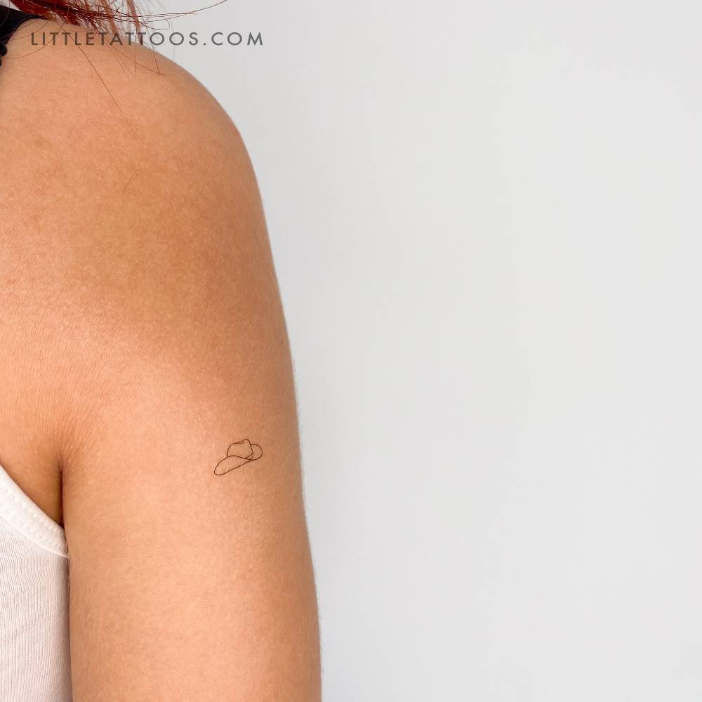 Tiny minimalistic cowboy hat temporary tattoo located on the upper arm.