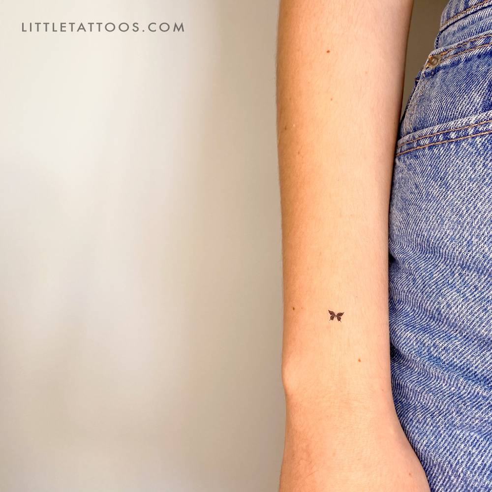 Tiny minimalistic black butterfly temporary tattoo.