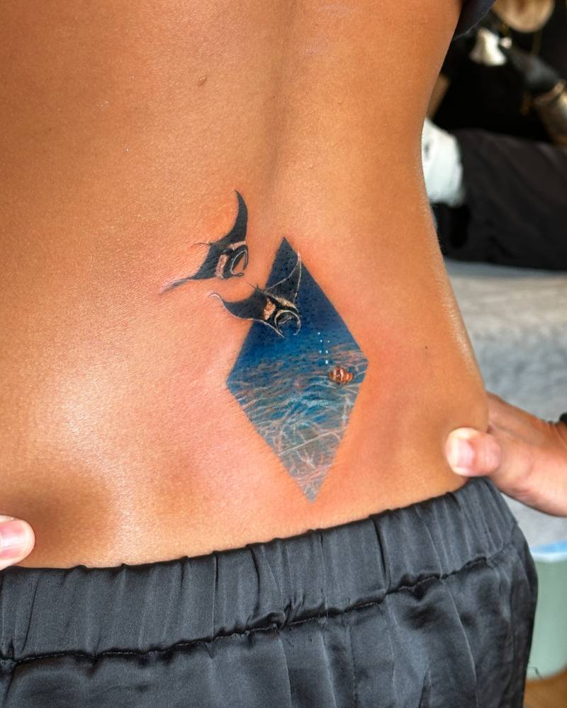 Manta rays tattoo in micro-realistic style placed on the lower back.