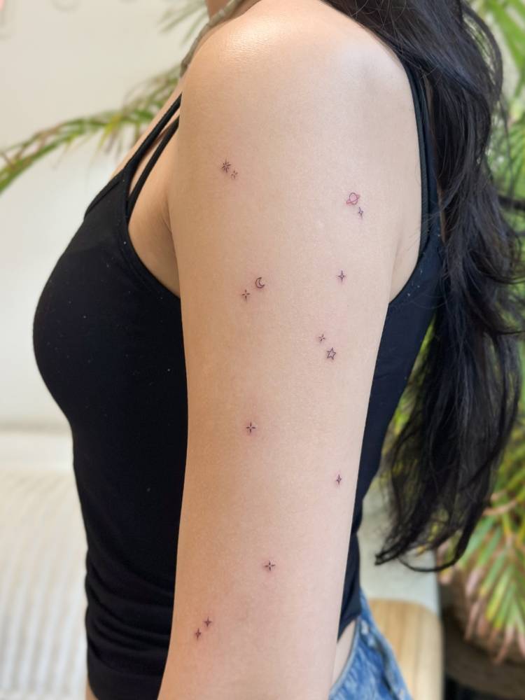 Galaxy tattoo in minimalistic style located on the upper arm.