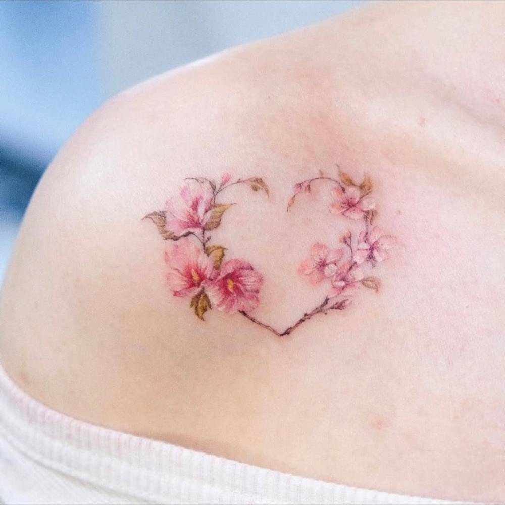 Watercolor style flower wreath tattoo located on the shoulder.