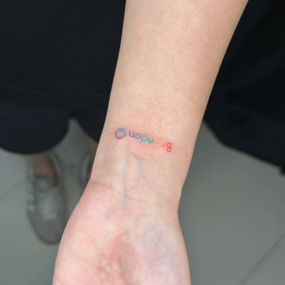 Hand poked name "Brandon" tattoo located on the wrist.