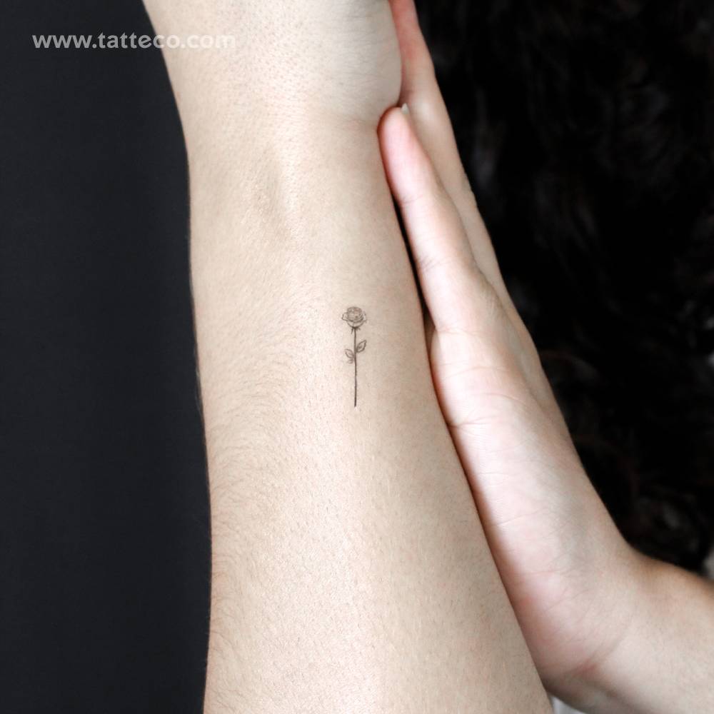 Small fine line rose semi-permanent tattoo located on the wrist.
