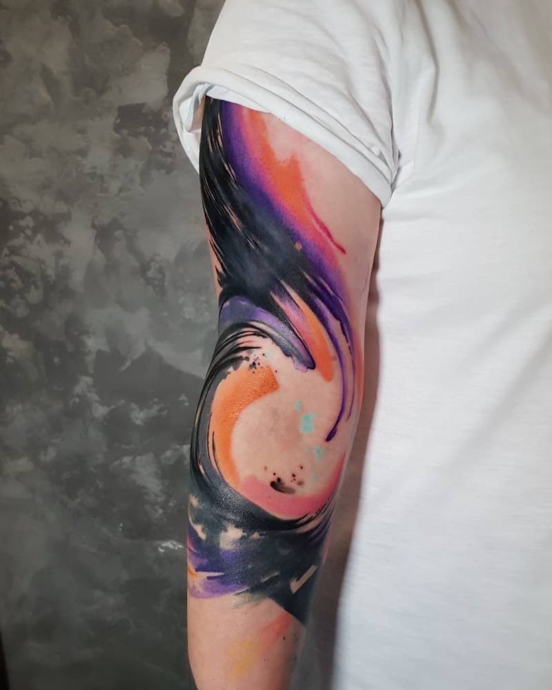 Abstract Brush stroke wave tattoo located on the arm.