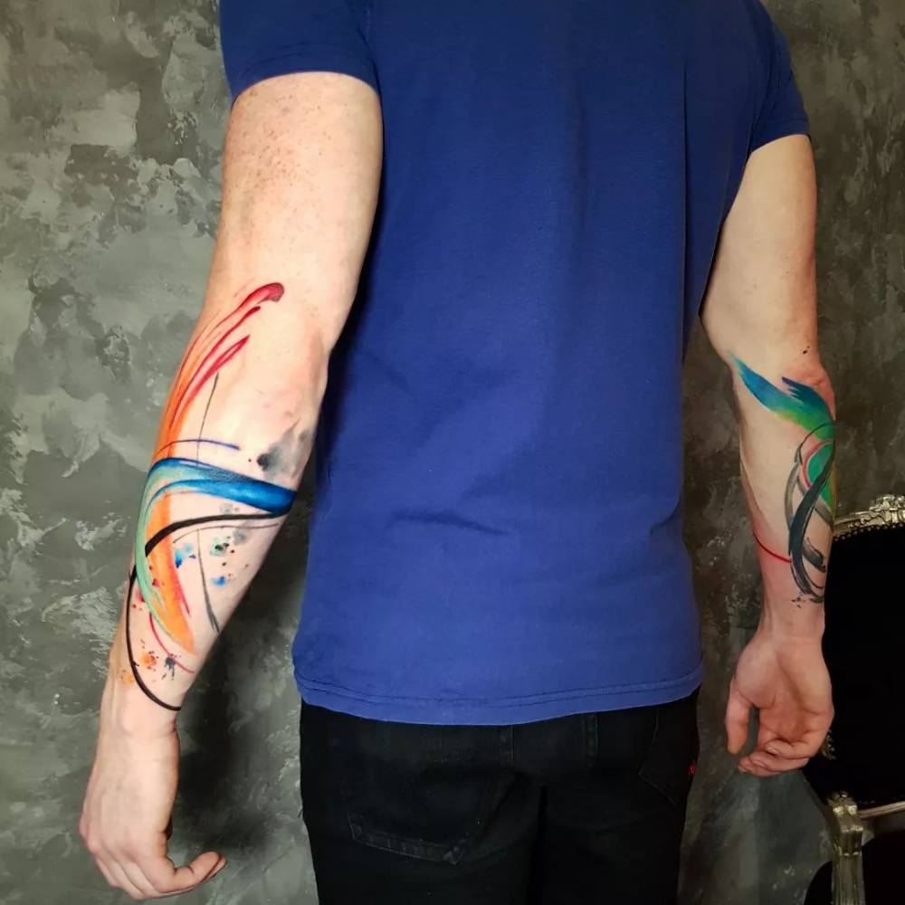 Individual matching abstract brush stroke tattoo on the forearms.