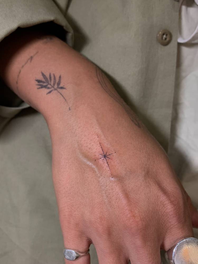 North star tattoo in minimalistic style located on the hand.