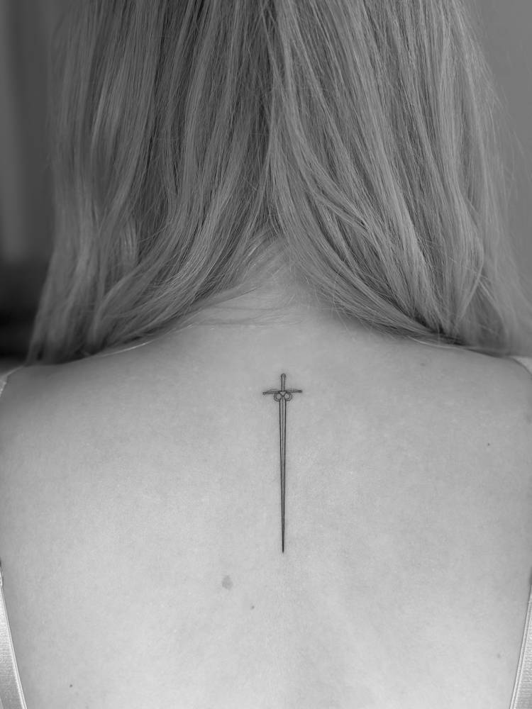 Sword tattoo done on the upper back, fine line style.