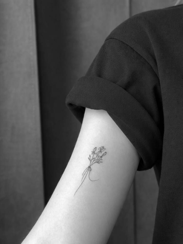 Minimalistic flower bouquet tattoo in fine line style.