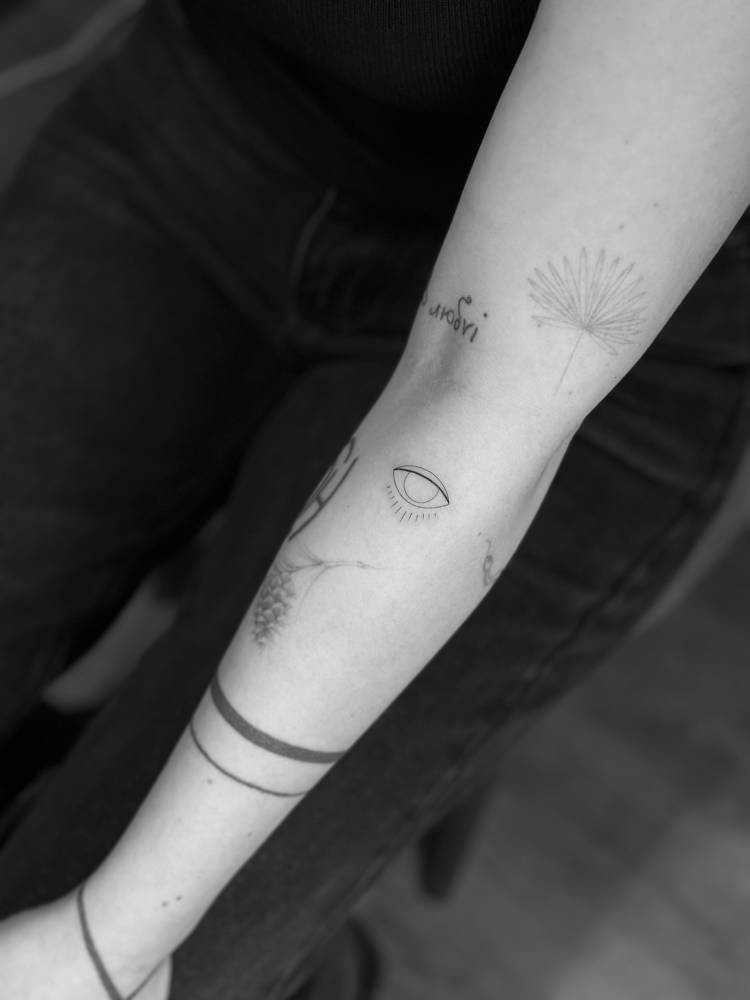 Little evil eye tattoo in minimalistic style placed on the forearm.