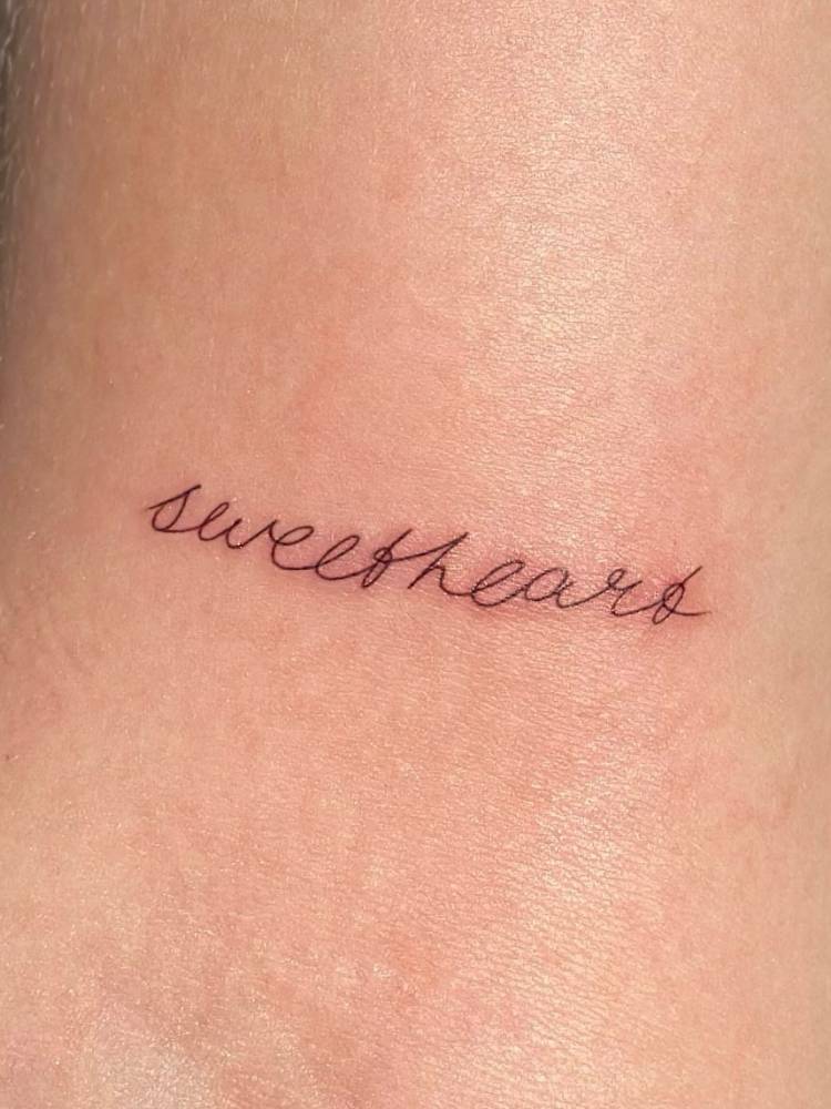 Handwritten font word "sweetheart" tattoo located on the bicep.