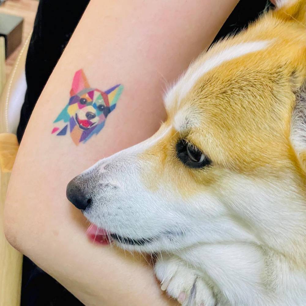 Low poly Corgi portrait tattoo located on the upper arm.