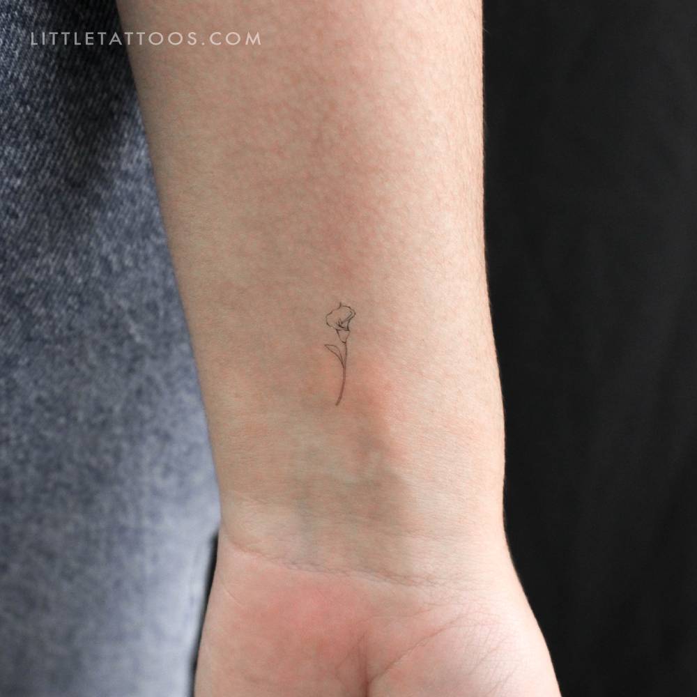 Little fine line style calla lily temporary tattoo located on the wrist.