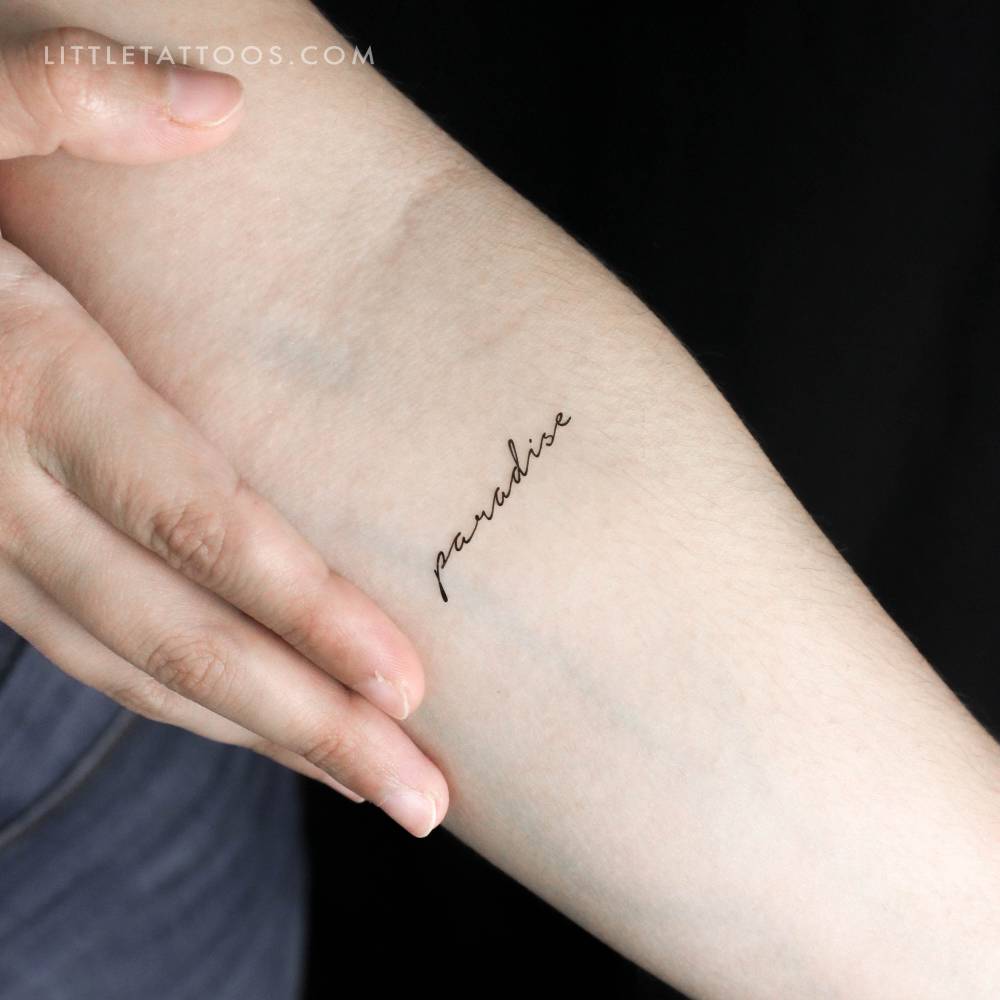 Handwritten font word "paradise" temporary tattoo located on the inner forearm.