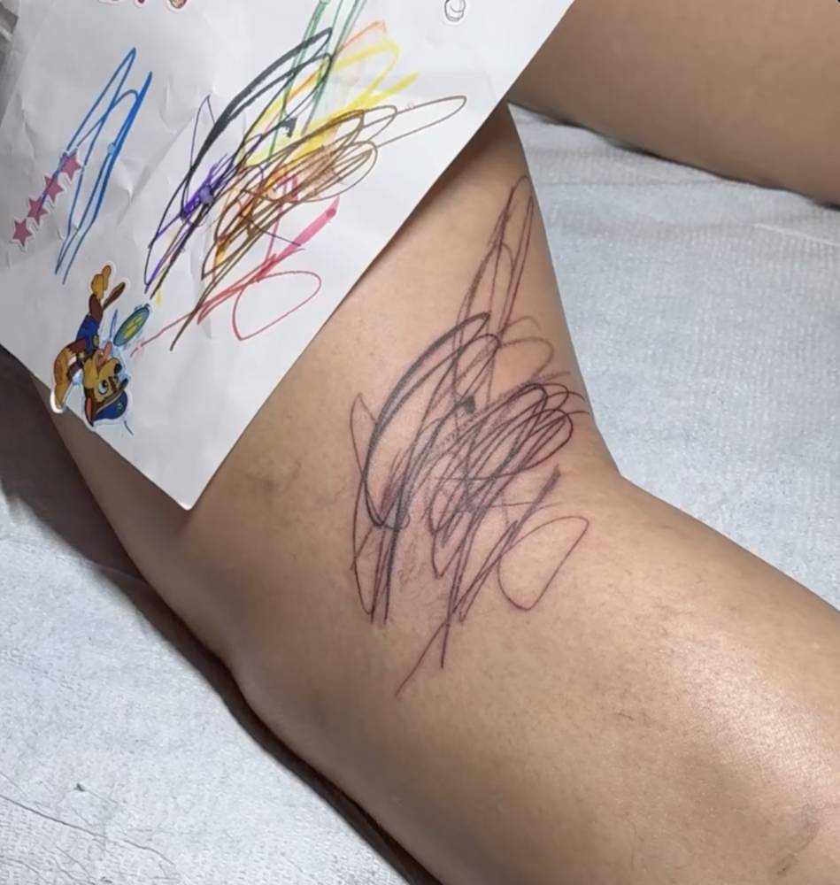 Scribble designed by her children tattooed on Rihanna's leg.