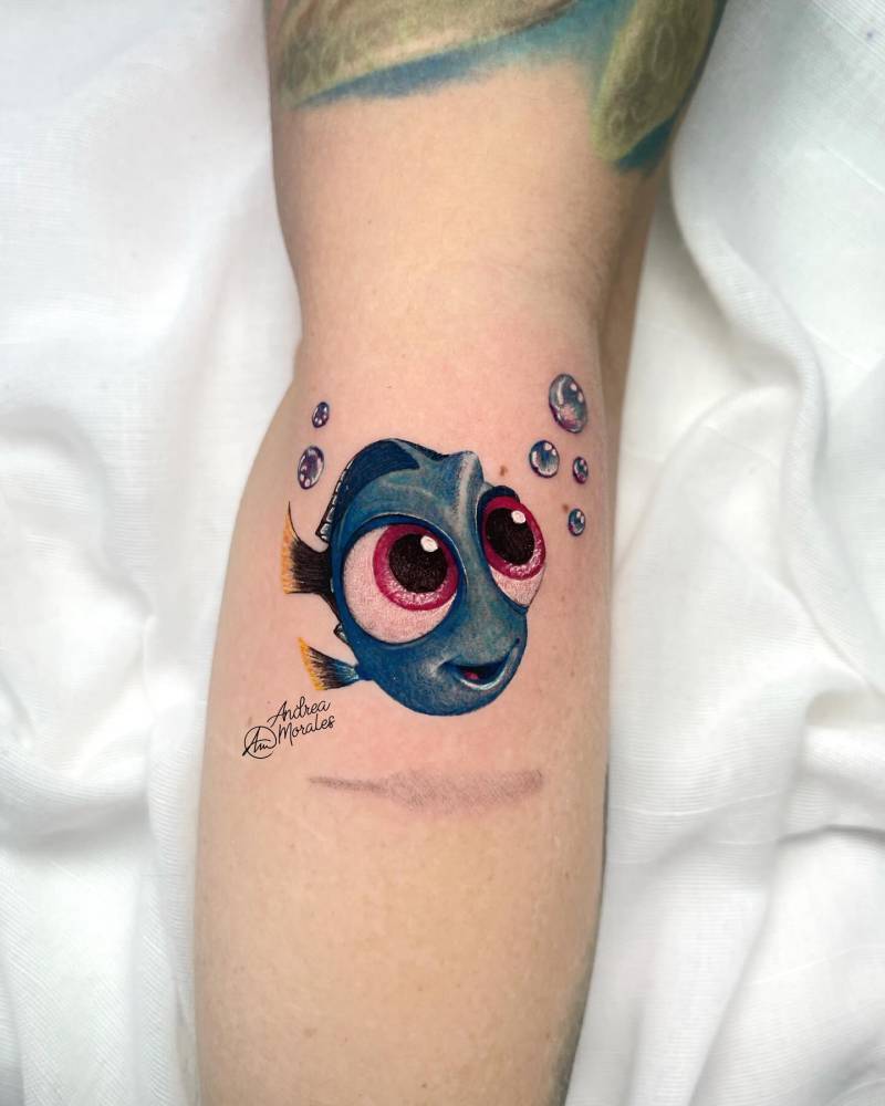 Cartoon style Dory tattoo located on the forearm.