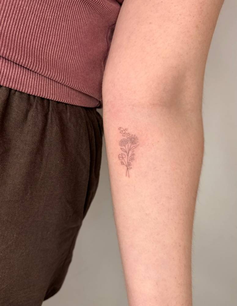 Little flower bouquet tattoo located on the inner forearm.