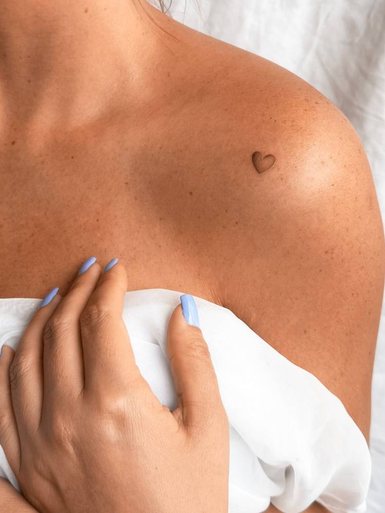 Spectrum heart tattoo located on the shoulder.