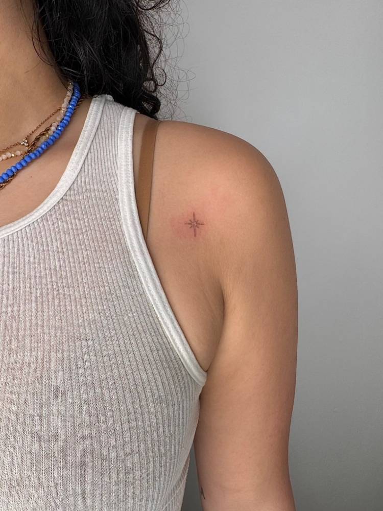 North star tattoo in fine line style placed on the shoulder.