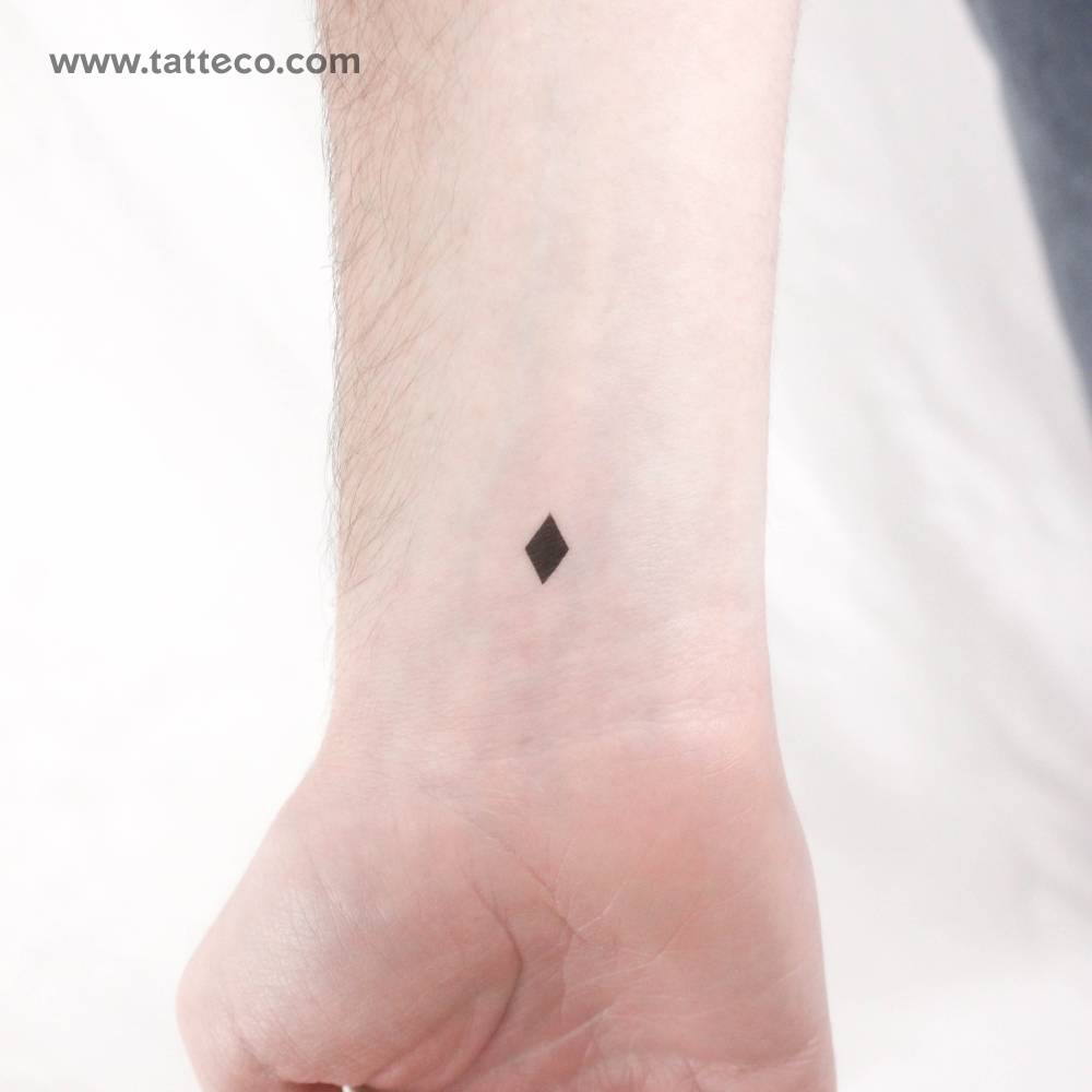 Black rhombus temporary tattoo located on the wrist.