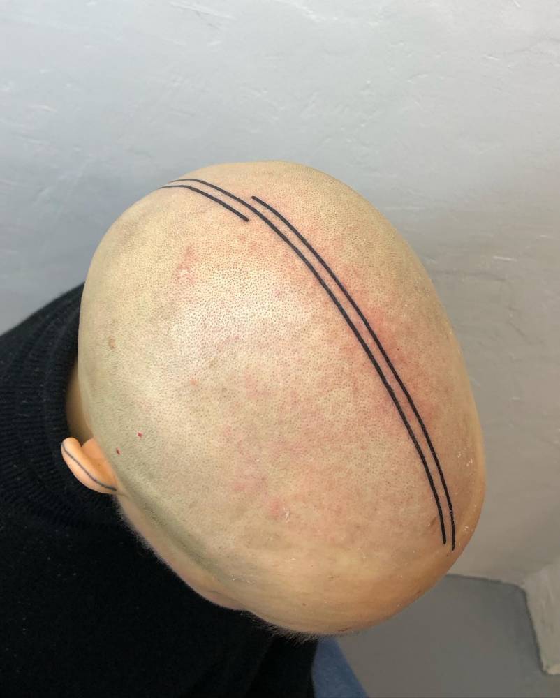 Lines tattoo located on the head, minimalistic style.