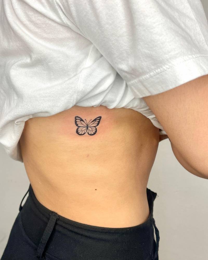 Illustrative style butterfly tattoo located on the rib.