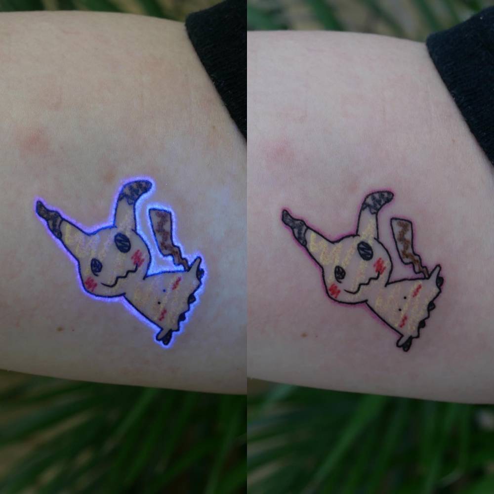 Mimikyu tattoo in UV ink located on the inner forearm.