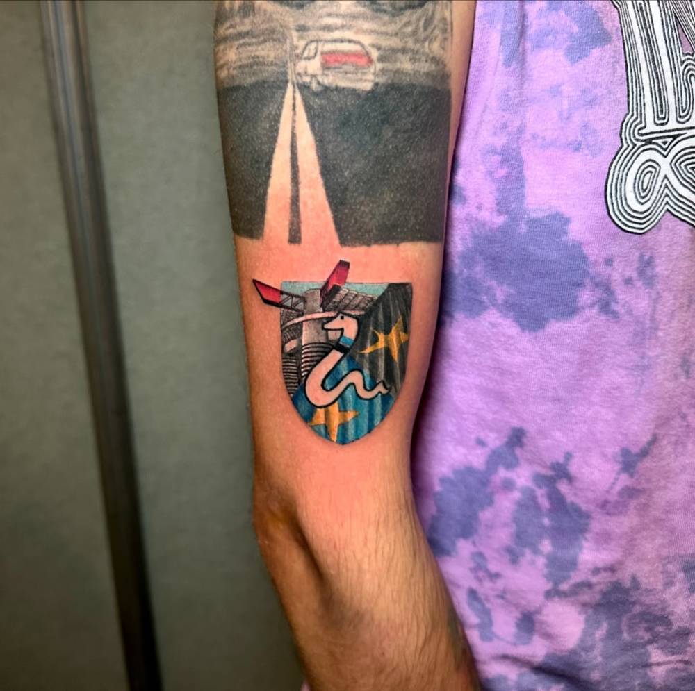 Illustrative style Inter Milan tattoo located on the upper arm.