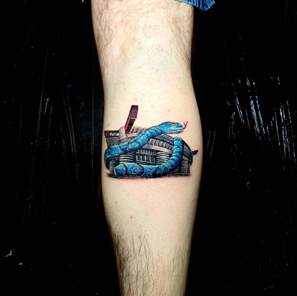 San Siro and snake tattoo in illustrative style located on the calf.