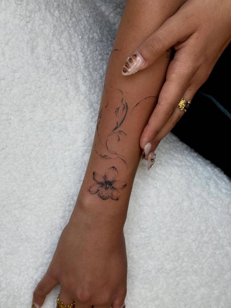 Orchid tattoo in micro-realistic style located on the wrist.