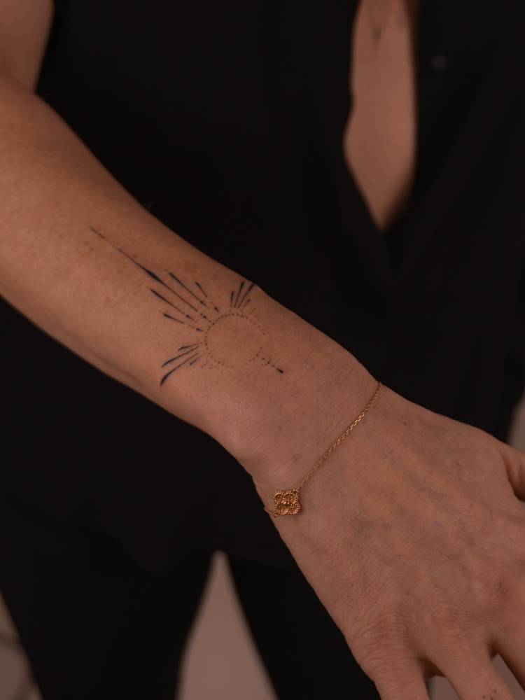 Hand poked ornamental tattoo located on the wrist.