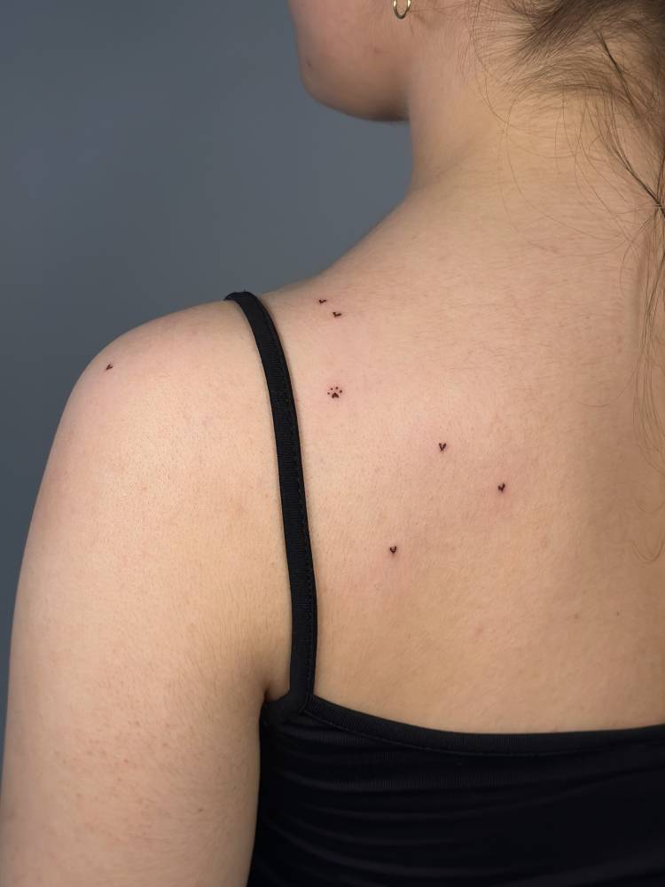 Hearts and paw freckles tattoo located on the shoulder blade.
