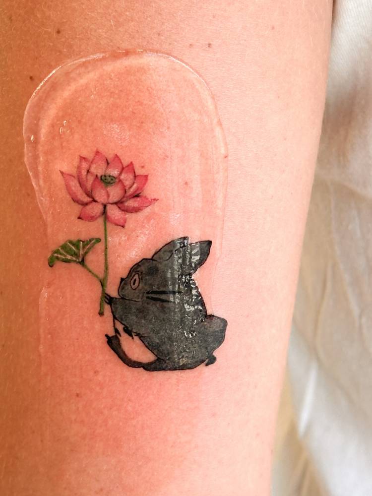 Cartoon style Chuu Totoro tattoo located on the upper arm.