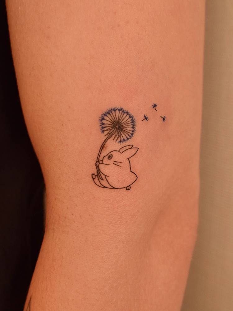 Chuu Totoro tattoo in cartoon style done on the upper arm.