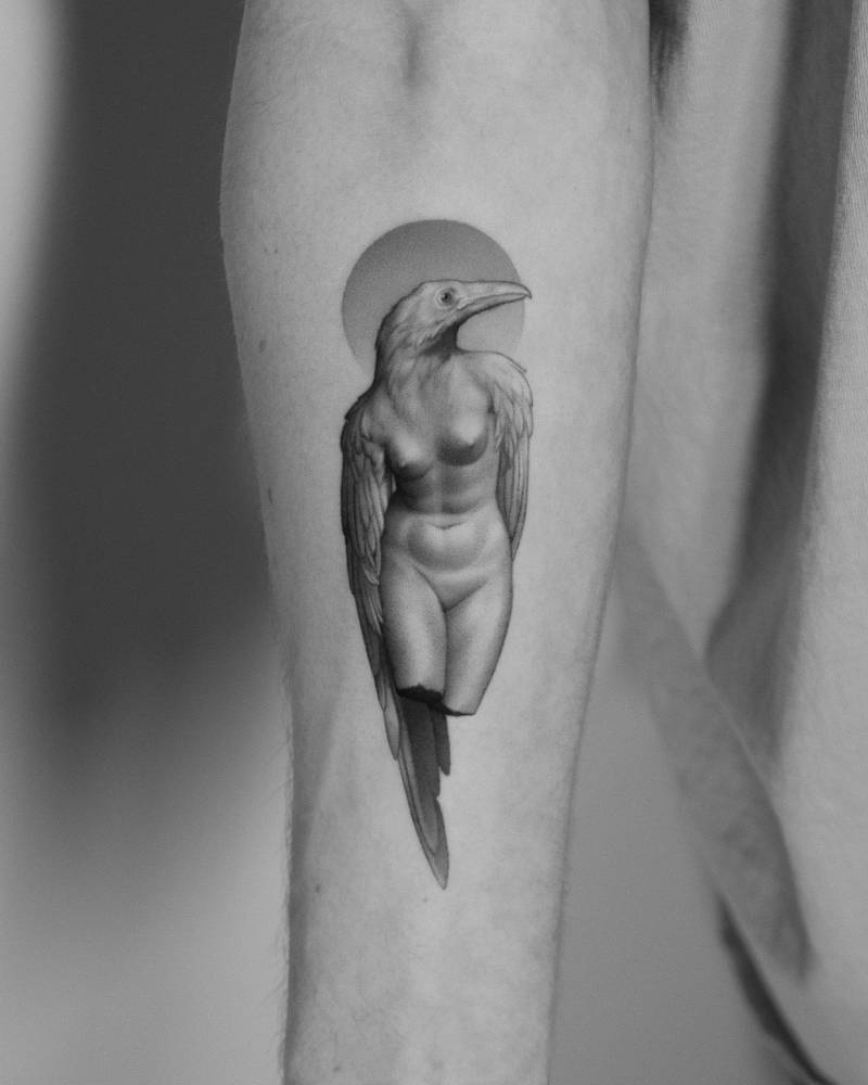Surrealistic style raven woman tattooed on the inner forearm.