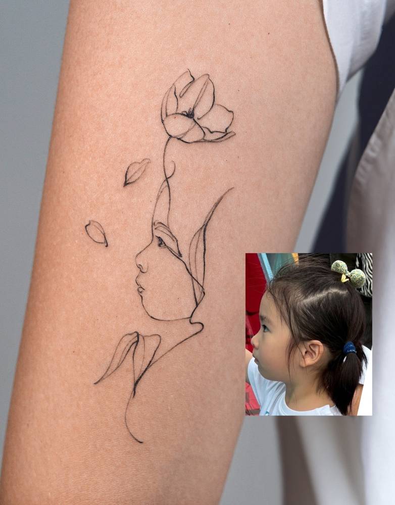 Child portrait tattoo in sketch work style located on the inner forearm.