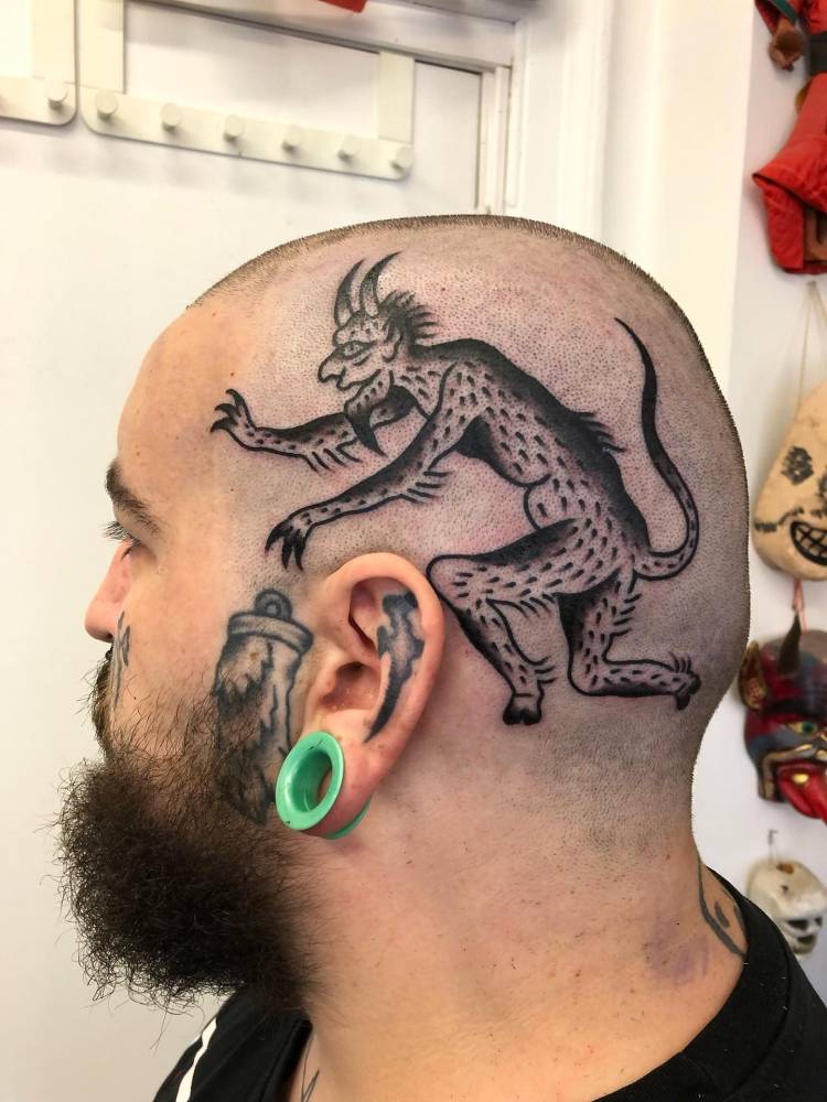 Blackwork style devil tattoo located on the head.