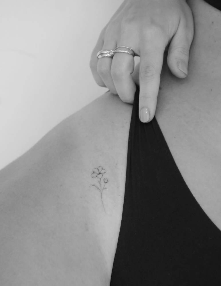Single needle flower tattoo located on the pelvis.